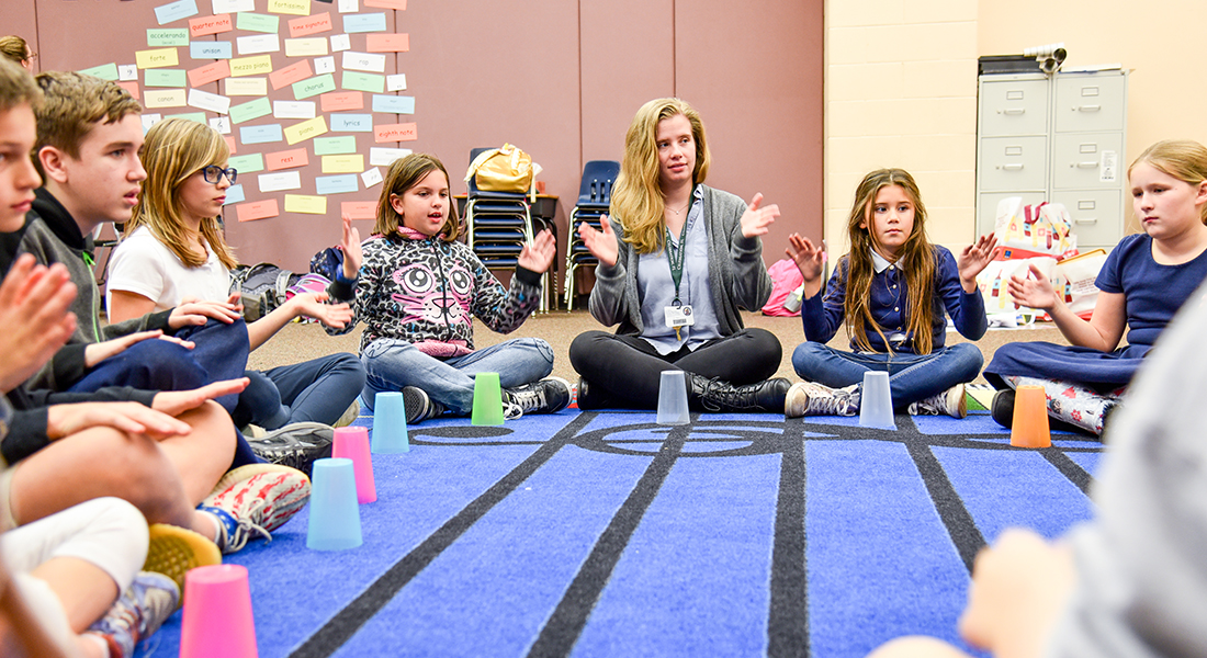 Kids sitting in circle clapping hands